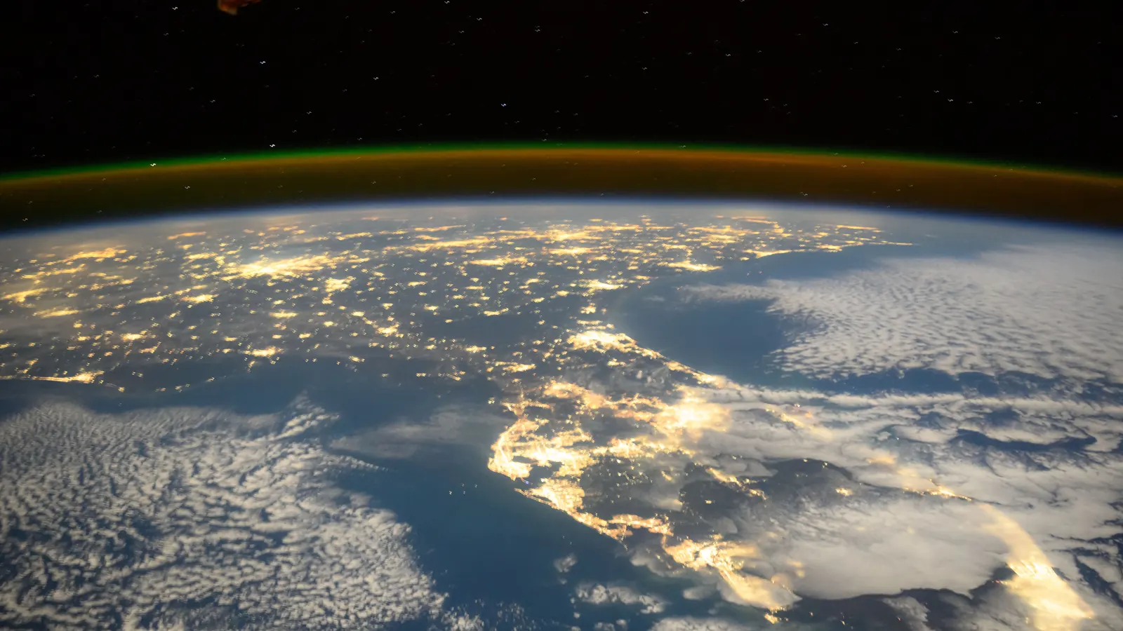 Florida's city lights at night, with both the Gulf and Atlantic coasts visible under a thin band of green airglow, photographed by NASA astronaut Suni Williams from the International Space Station on November 17, 2024