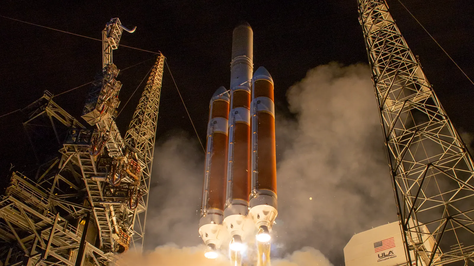 A United Launch Alliance Delta IV Heavy rocket lifting off between its pad towers at night from Cape Canaveral on August 12, 2018, carrying NASA's Parker Solar Probe