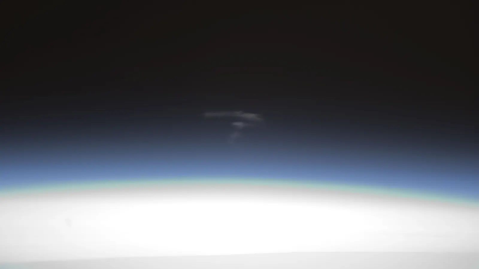 Glowing streaks of debris from Europe's ATV-3 cargo ship above Earth's bright limb during its planned reentry over the Pacific on 3 October 2012, photographed from the International Space Station