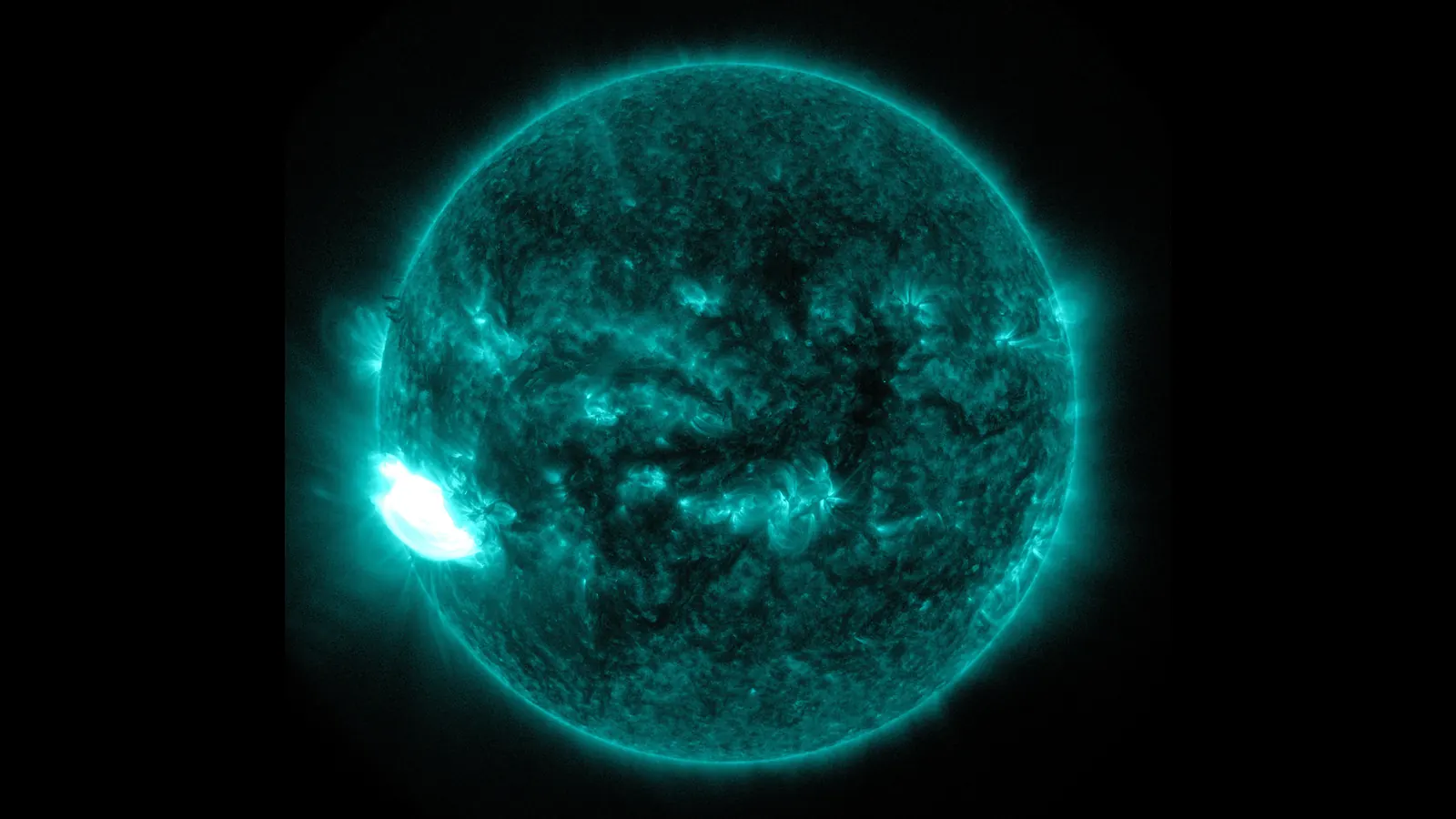 The Sun in extreme ultraviolet light, shown in teal, from NASA's Solar Dynamics Observatory, with a bright X-class flare erupting near its left edge in October 2014