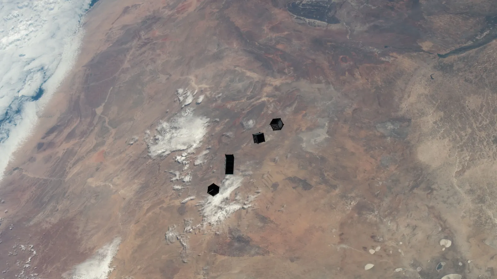 Four CubeSats drifting away after release from a small-satellite deployer on the International Space Station's Kibo module, high above Namibia, on December 2, 2022