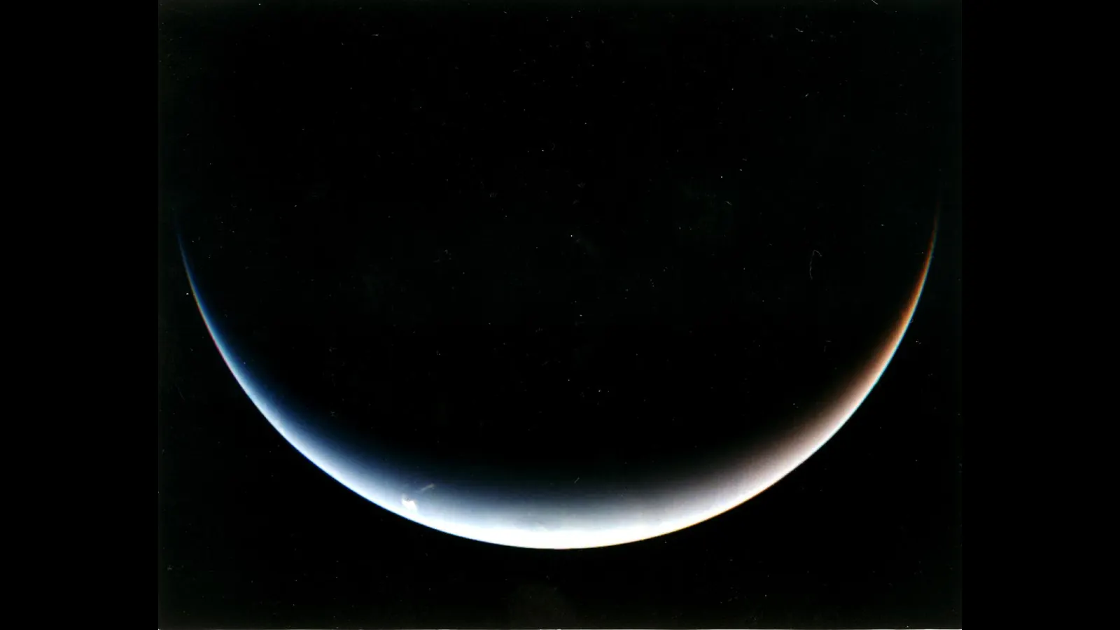 Neptune's south pole as a thin sunlit crescent, photographed by Voyager 2 as the spacecraft sped away on a southward path after its 1989 flyby